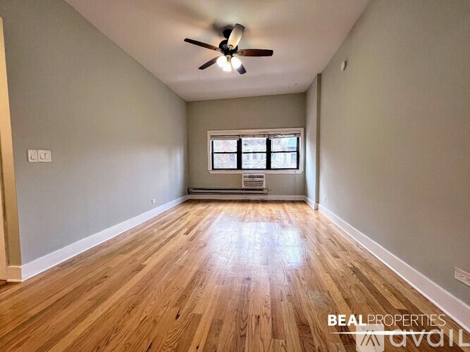 A room with wooden flooring and a ceiling fan.
