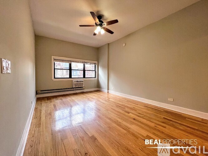 A room with a ceiling fan and wooden flooring.