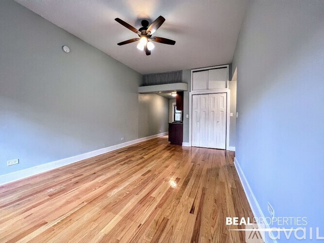 A room with wooden flooring and a ceiling fan.