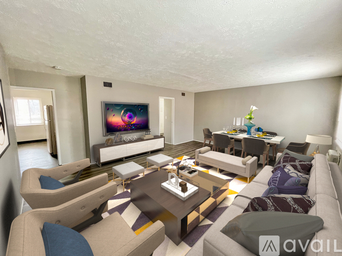 A living room with a large couch, a coffee table, and a television.