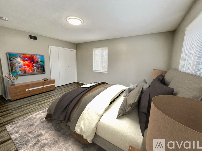 A bedroom with a large bed and a painting on the wall.