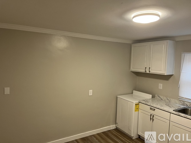 A kitchen with white cabinets and a sink.