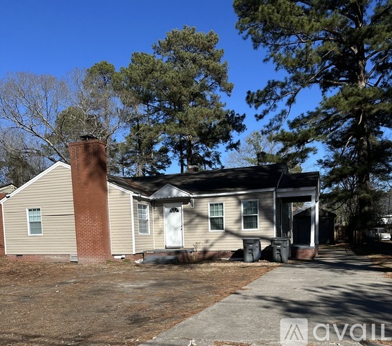 A house with a brown chimney is surrounded by trees.
