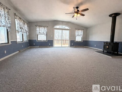 A spacious room with a fireplace and a ceiling fan.