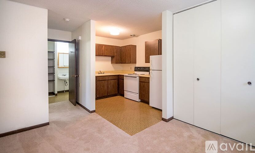 A kitchen with white appliances and wooden cabinets.