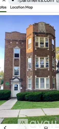 A tall brick building with a white door and windows.