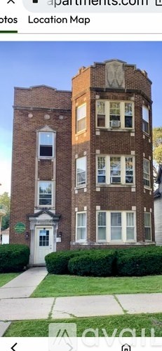 A tall brick building with a white door and windows.