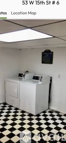 A white refrigerator in a room with black and white checkered floor.