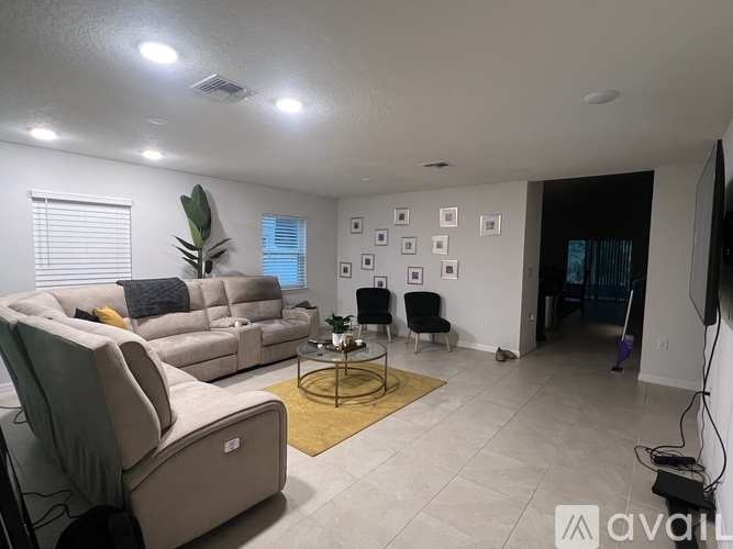 A living room with a sofa set, a coffee table, and a TV.