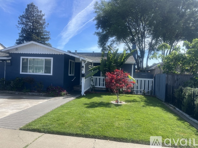 A house with a blue exterior and a white fence.