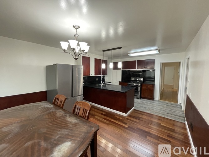A kitchen with a wooden table and chairs in the foreground.