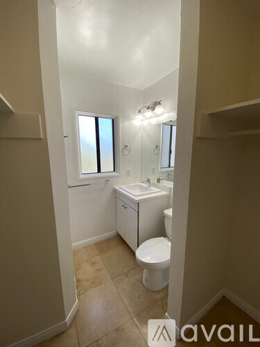 A bathroom with a toilet, sink, and mirror.