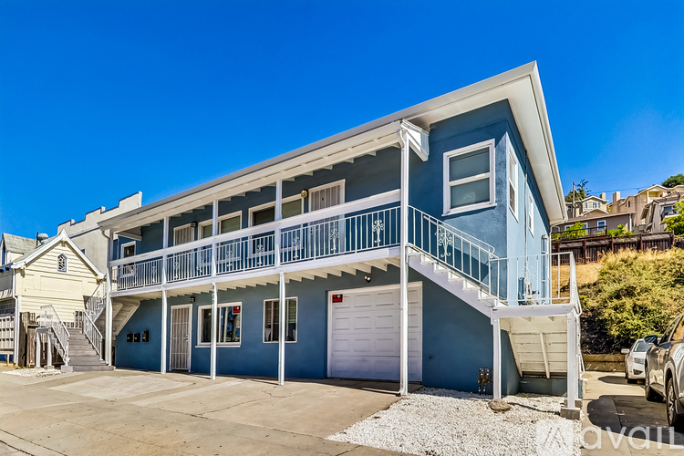 A blue two-story house with a balcony and a garage.