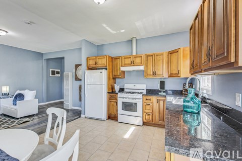 A kitchen with a white refrigerator, white stove, and wooden cabinets.
