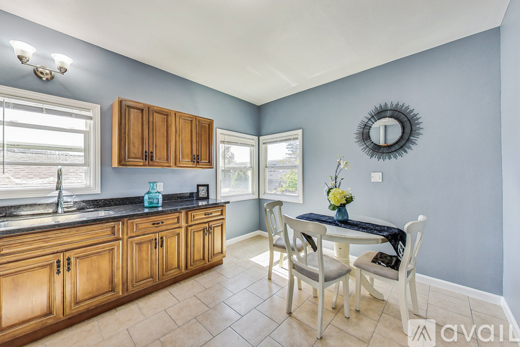 A kitchen with wooden cabinets and a black countertop.