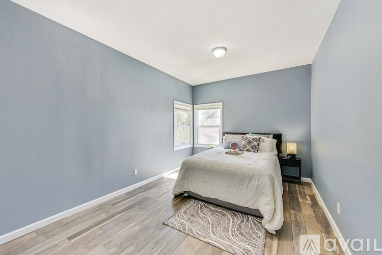 A bedroom with a bed, nightstand, and window.