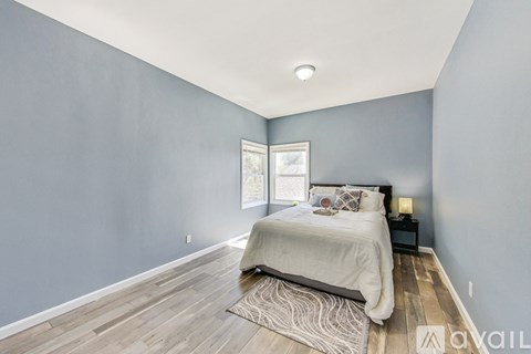 A bedroom with a bed, nightstand, and window.