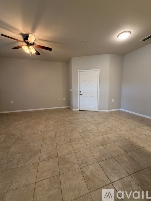A room with a ceiling fan and tile flooring.