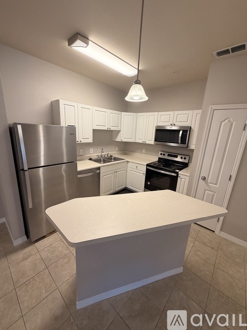 A kitchen with a refrigerator, microwave, oven, and dishwasher.