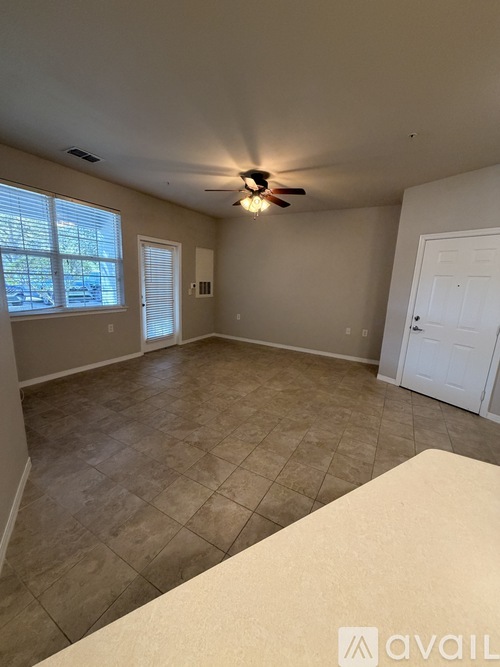 A room with a ceiling fan and tiled floor.