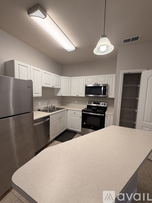 A kitchen with white cabinets and a stainless steel refrigerator.