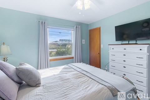 A bedroom with a large bed and a flat screen TV mounted on the wall.