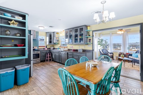 A kitchen with a table and chairs in front of it.