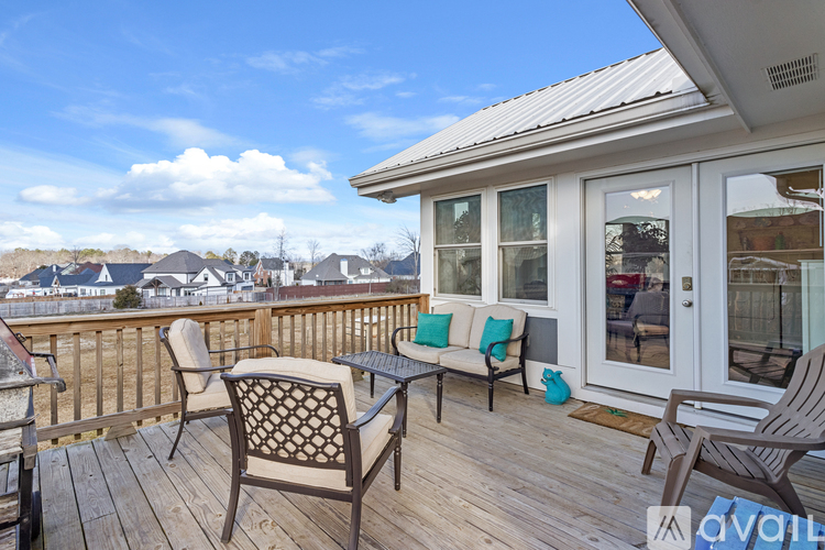 A wooden deck with a table and chairs overlooking a residential area.