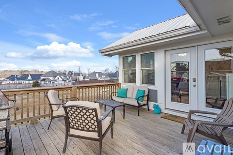 A wooden deck with a table and chairs overlooking a residential area.