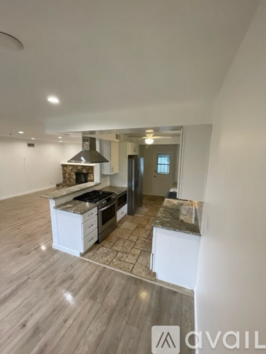 A modern kitchen with a central island and a stove top oven.