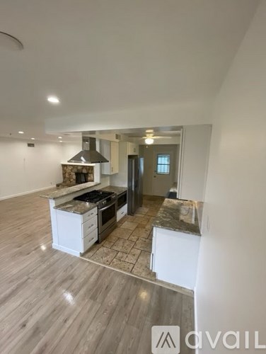 A modern kitchen with a central island and a stove top oven.
