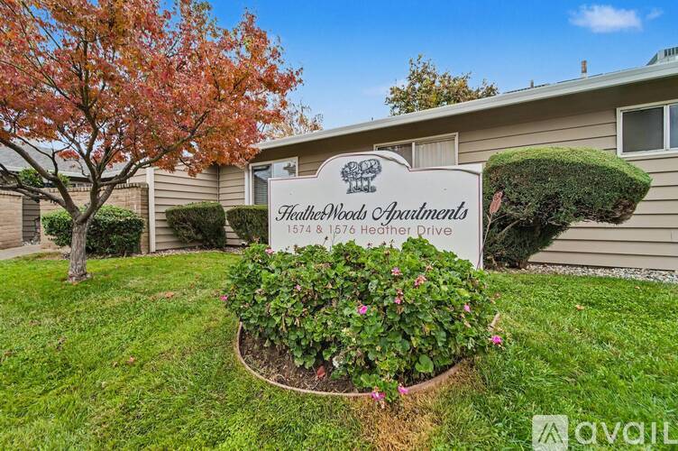 A sign for Heatherwood Apartments is in front of a building.