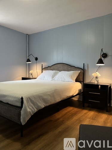 A bedroom with a bed, nightstand, and lamp.