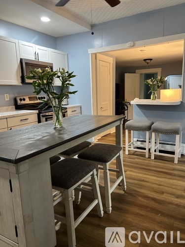 A kitchen with a bar stool and a plant on the counter.