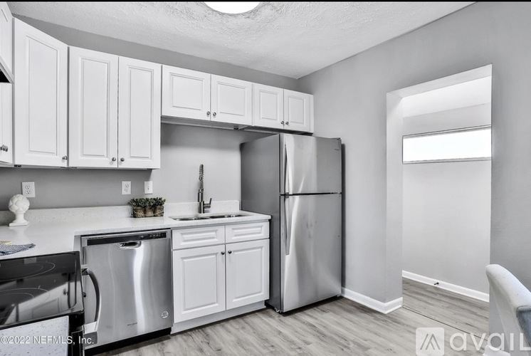 A kitchen with white cabinets and stainless steel appliances.