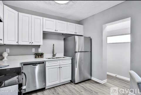 A kitchen with white cabinets and stainless steel appliances.
