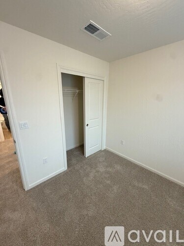 A room with a carpeted floor and a doorway leading to another room.