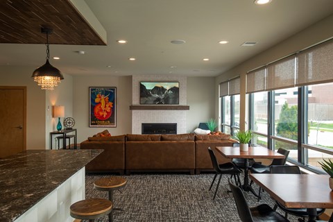 A modern living room with a fireplace and a painting of a sunset.