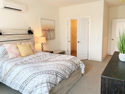 A bedroom with a patterned bedspread and a large bed.