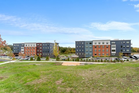 A large grassy area in front of apartment buildings.