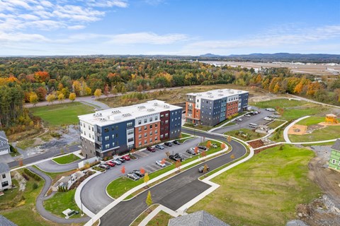 A large building complex with a parking lot in front.