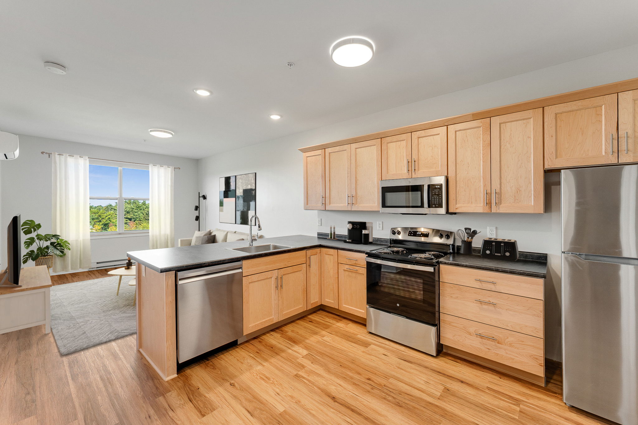 A modern kitchen with wooden cabinets and stainless steel appliances.