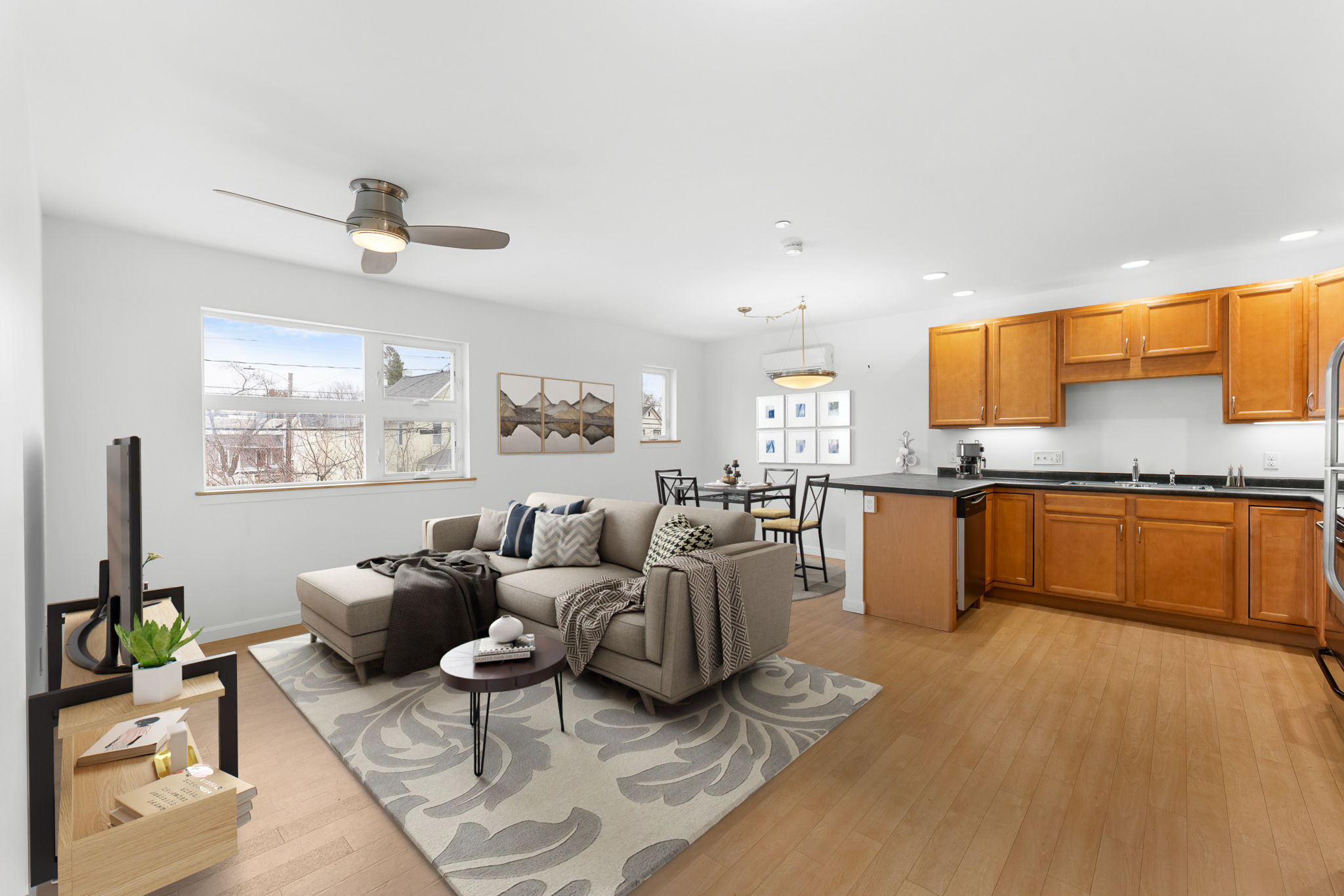 A living room with a grey couch and a wooden floor.