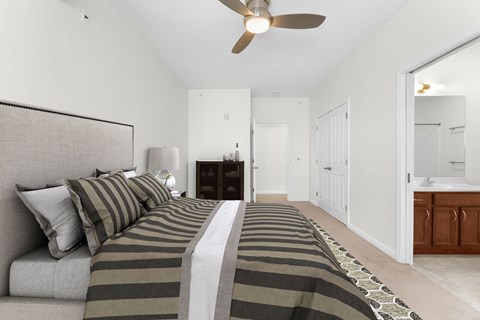 A bedroom with a large bed and a ceiling fan.