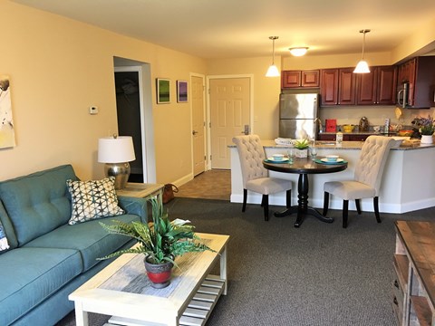 A living room with a couch, a table, and a plant.