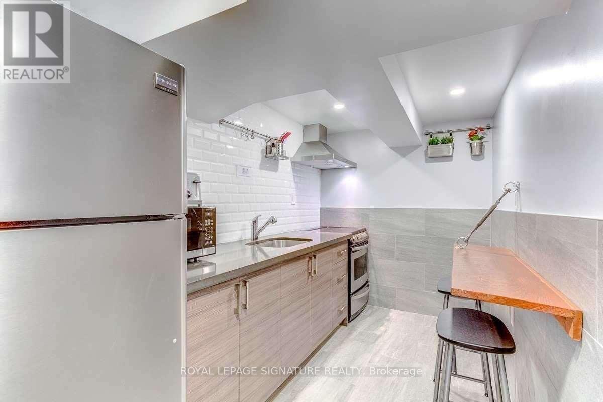 A modern kitchen with a refrigerator, sink, and stove.