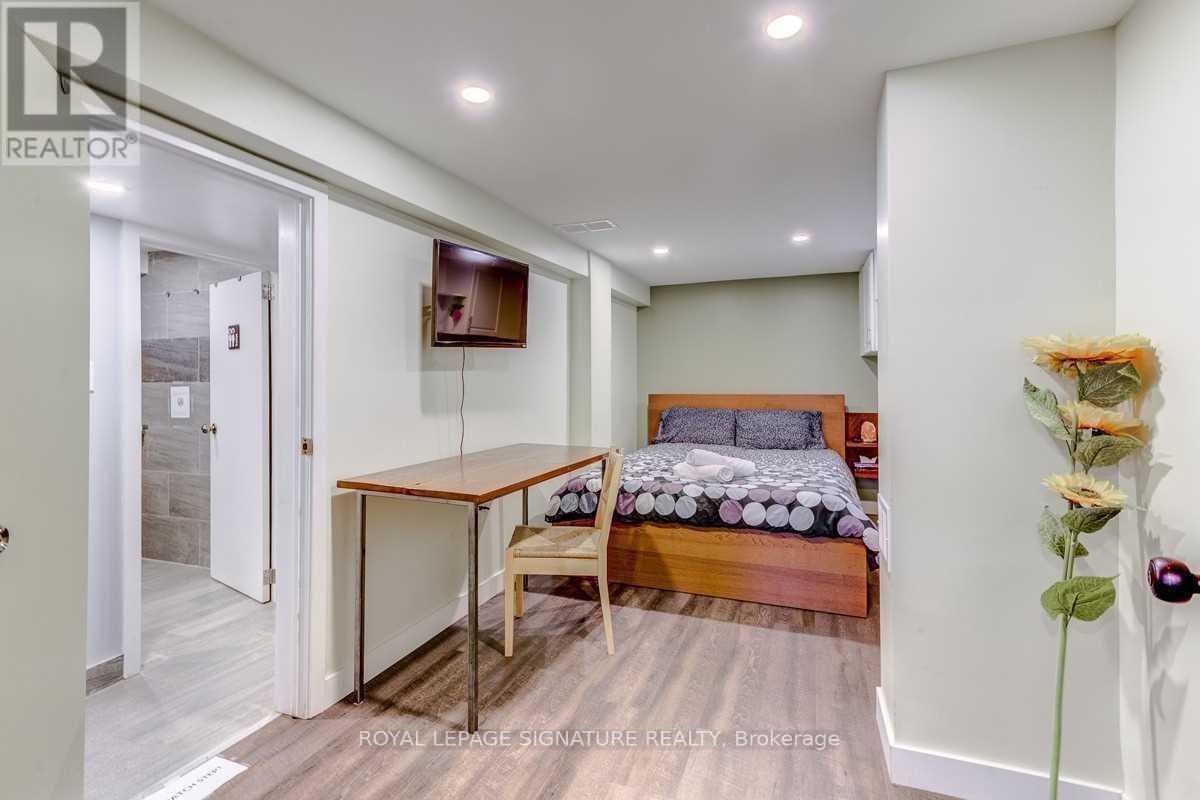 A bedroom with a bed, a table, and a vase of flowers.