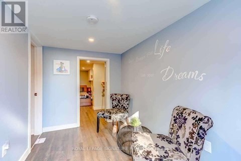 A living room with a couch and a wall decal that says "Life Dreams".