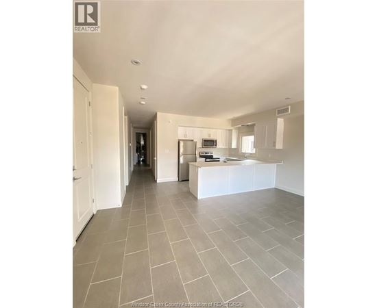 A spacious kitchen with white cabinets and a central island.