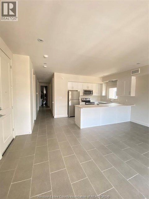 A spacious kitchen with white cabinets and a central island.